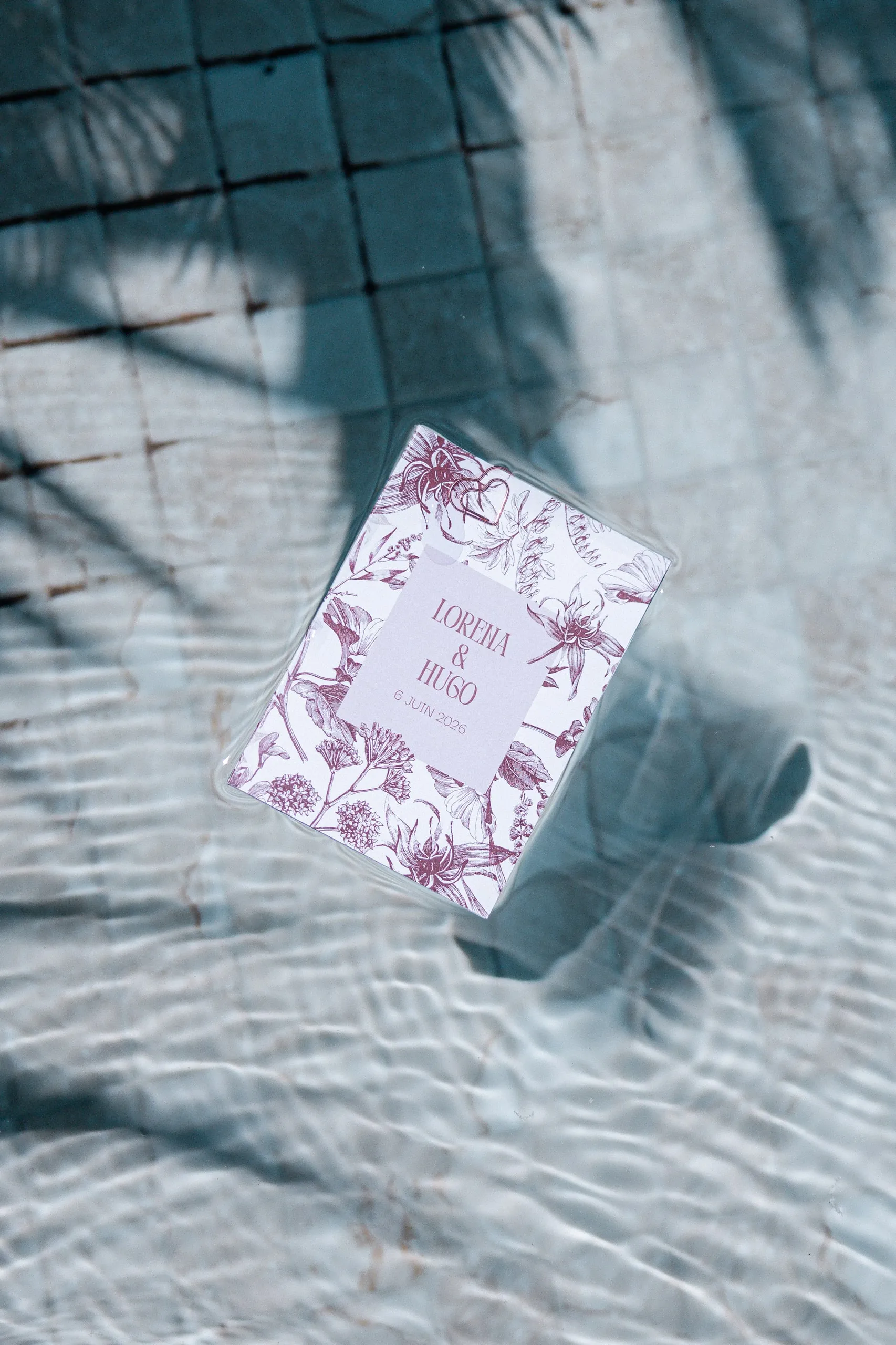 Le faire-part floral de Lorena et Hugo, posé à l'ombre d'un palmier