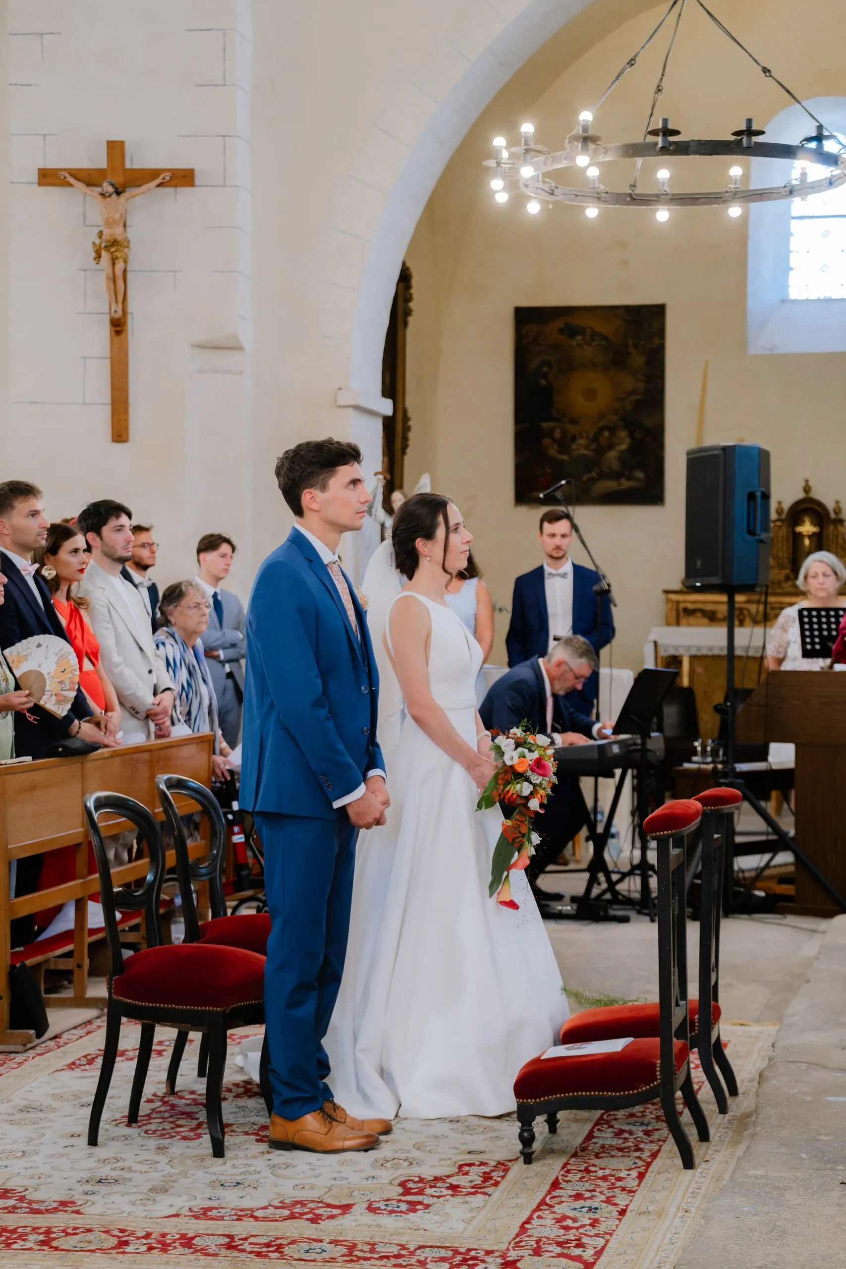 Wieke et Jean devant l'autel, sous les guirlandes lumineuses de l'église