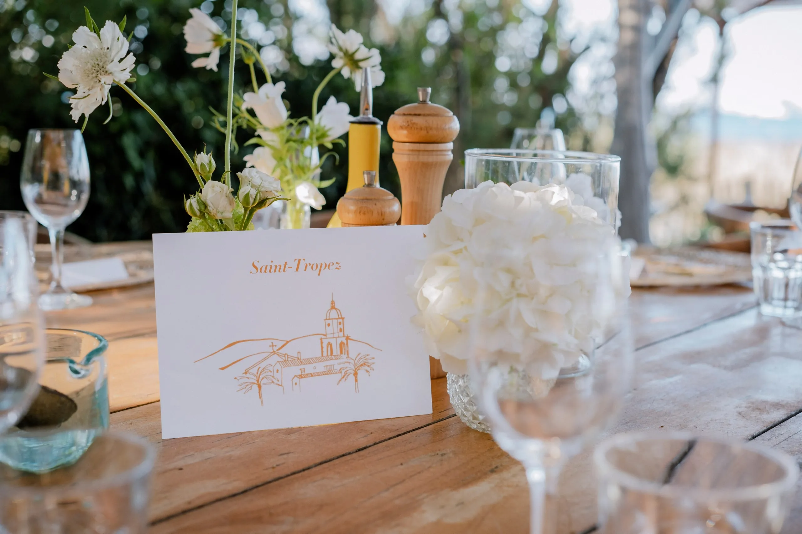Une table dressée de fleurs blanches, avec son marque-place
