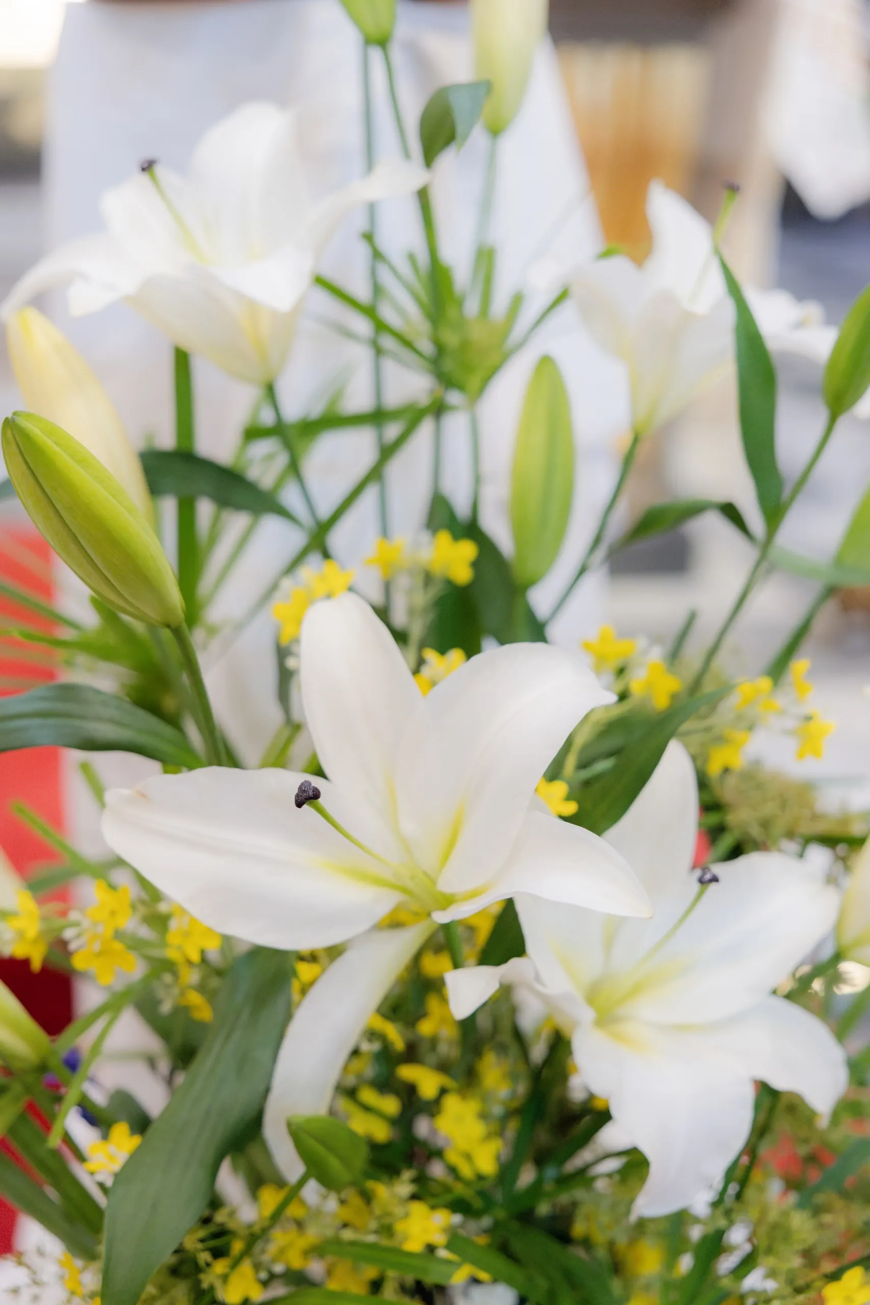 Un bouquet de lys blancs et de mimosa près de l'autel