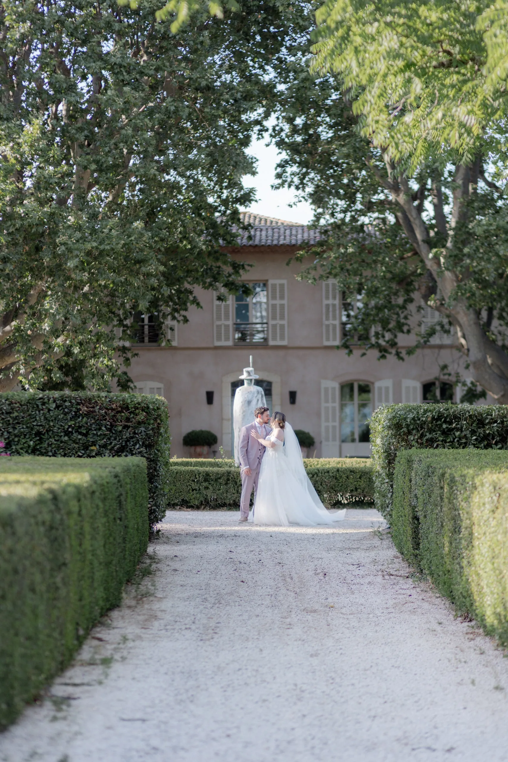 Lorena et Hugo minuscules au bout de l'allée de buis, devant la bastide