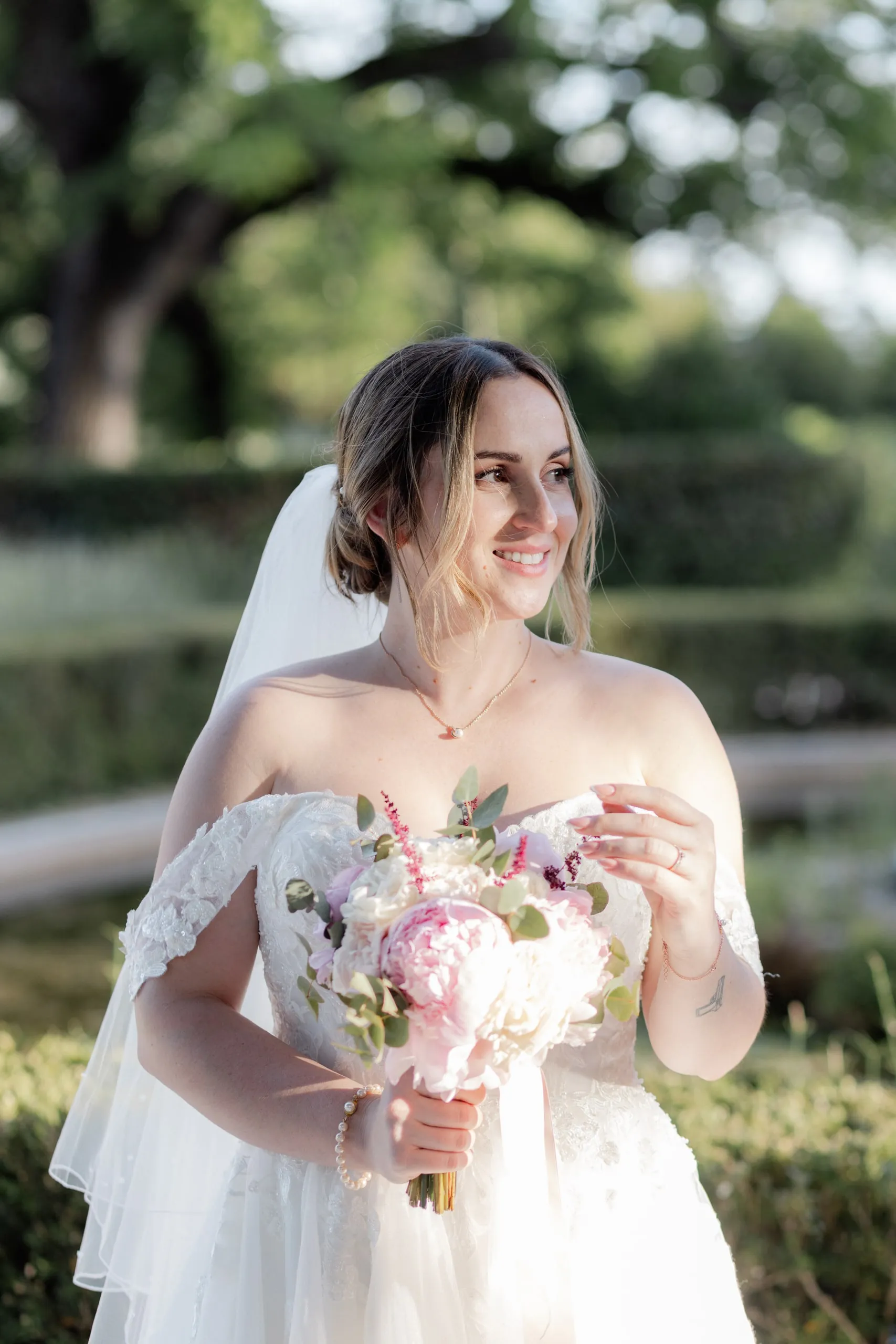 Lorena rit, son bouquet à la main, dans le parc