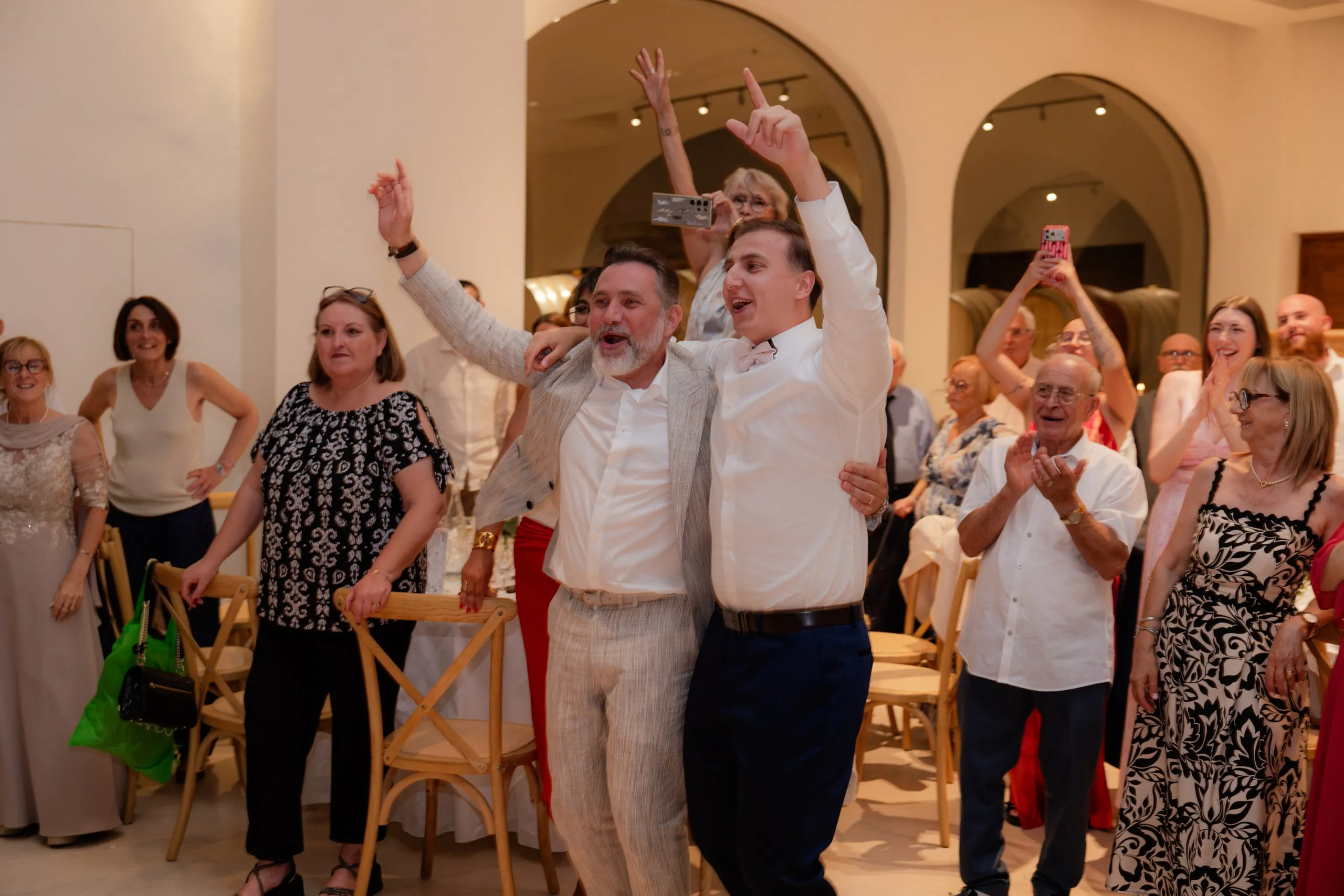 Les invités debout, bras en l'air, acclament les mariés